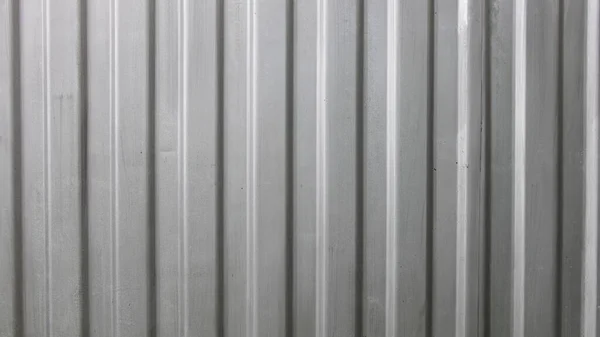Gray painted metal corrugated sheet fence surface vertical lines industrial texture background