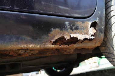 Arabanın kapı pervazının aşınmasıyla kapanmış, kıştan sonra aracın gövdesinde paslanmış bir delik var.