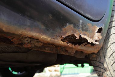 Arabanın kapısının korozyonundan, kapağı kapatın, aracın gövdesinde tuzlu yoldan sonra paslı bir delik var.