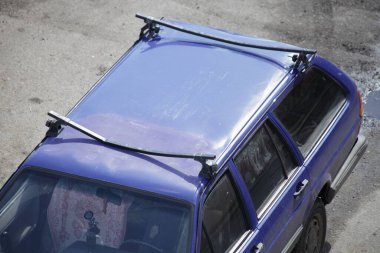 Üst görüşü aşırı yükledikten sonra yolcu aracının eğimli rayları olan eski hasarlı araba çatısı, taşımacılık için bagaj ekipmanları