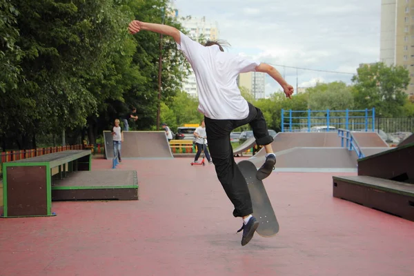 安全装置なしでジャンプティーンスケートボーダー 白いライダーの少年は 晴れた夏の日にスケートボード上のトリックを作る ヨーロッパの極端な若者の都市スポーツ屋外 — ストック写真
