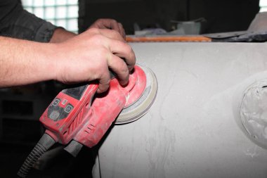 Servis elemanının eli, araba parçalarını vibratörle öğütüyor, boyamadan önce, araç tamir servisi...