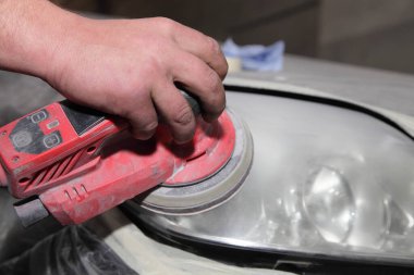 Araba farları, servis elemanlarının ellerini cilalamadan önce döndürme makinesiyle aşındırıcı gıcırdatma, araç yenileme teknolojisi.