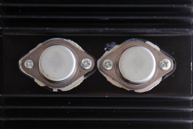 Elektrik dönüştürücüsünün arkasında büyük soğutma yüzgeçleri olan iki güçlü diyot.