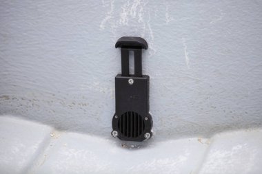 Opened drain scupper valve into the transom of a plastic RIB motor boat, preparing for navigation clipart