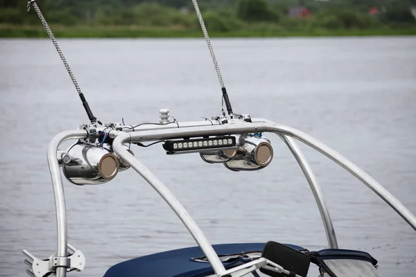 Modern boat chrome shiny sound bar, Audio box acoustic systems, headlinht and antanna in perspective on towing targa on motor boat outdoor at summer day at lake water background