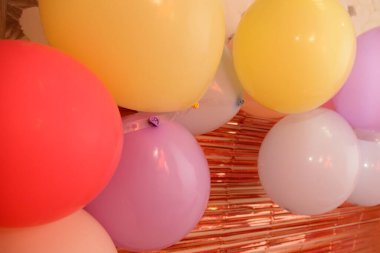 Birçok parlak renkli balon, çizgili bronz süsleme arka planı, tatil arka planı perspektifinde yakınlaşır.