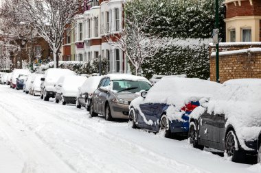 Londra, İngiltere, 18 Aralık 2010: Karlı teraslı evler ve kar yağışı sonrası donmuş arabalarla dolu sokak kışı şehri.