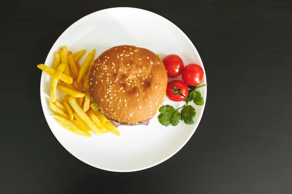 Välsmakande hamburgare på en vit platta — Stockfoto