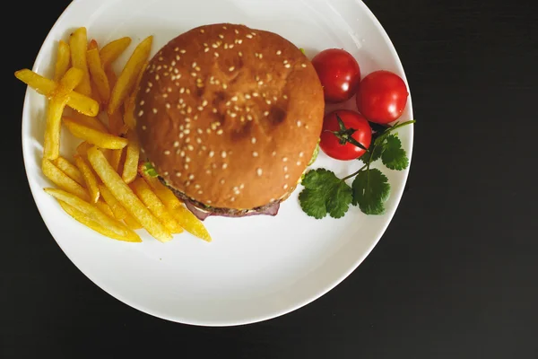 Tasty burger on a white plate — Stock Photo, Image