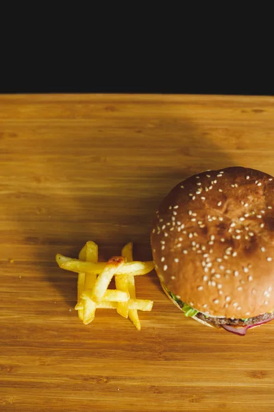 Hambúrguer saboroso em uma mesa de madeira — Fotografia de Stock