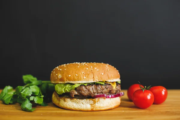 Sabrosa hamburguesa en un escritorio de madera —  Fotos de Stock