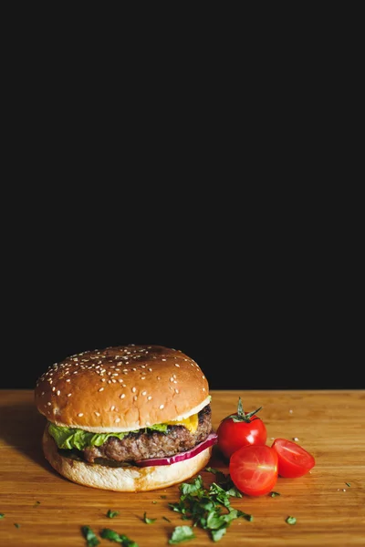 Tasty burger on a wooden desk — Stock Photo, Image