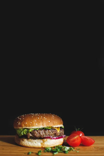 Tasty burger on a wooden desk — Stock Photo, Image