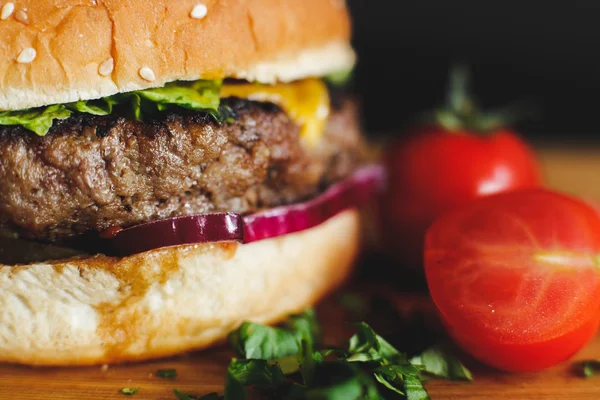 Hamburger savoureux sur un bureau en bois Images De Stock Libres De Droits