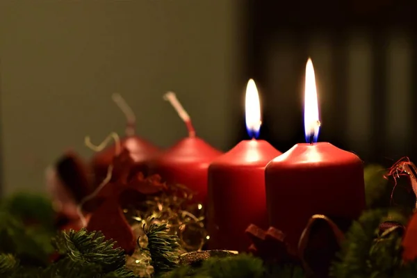 Close up af et adventsarrangement med 2 brændende stearinlys Royaltyfrie stock-billeder