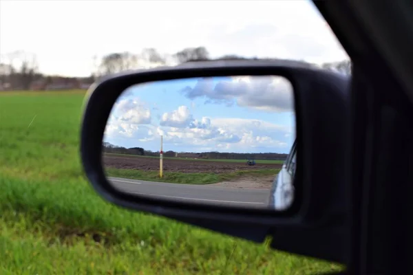 A paisagem é refletida no espelho exterior de um carro — Fotografia de Stock