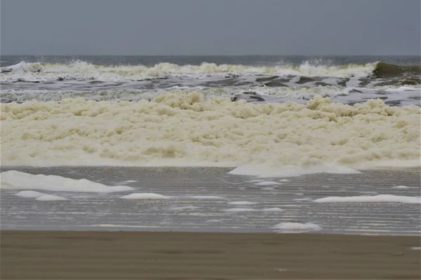 多云的日子里，北海海滩上的波浪和泡沫 — 图库照片