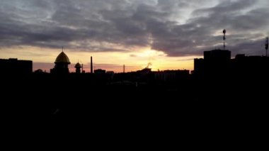 Şehrin üzerinde uçan bir İHA 'nın hava görüntüsü. Gökyüzünde gün batımı.