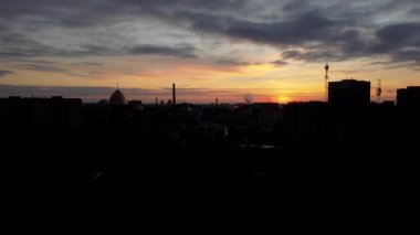 Şehrin üzerinde uçan bir İHA 'nın hava görüntüsü. Gökyüzünde gün batımı.