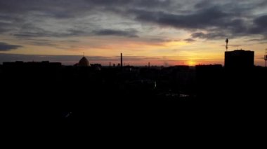 Şehrin üzerinde uçan bir İHA 'nın hava görüntüsü. Gökyüzünde gün batımı.