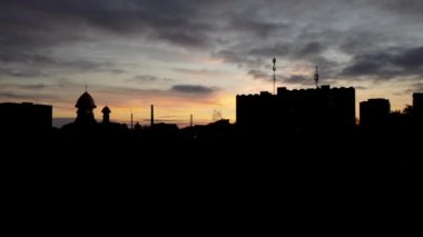 Şehrin üzerinde uçan bir İHA 'nın hava görüntüsü. Gökyüzünde gün batımı.