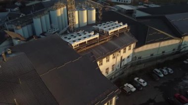 Bira üretim fabrikasının üzerinde uçan bir dronun hava görüntüsü, birkaç sıra tank....