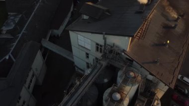 Bira üretim fabrikasının üzerinde uçan bir dronun hava görüntüsü, birkaç sıra tank....