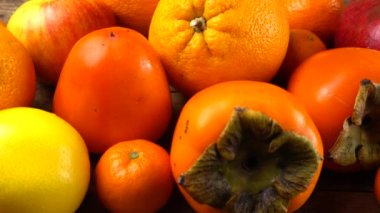 Mandalina, limon, hurma, portakal, elma ve nar eski ahşap bir tahtanın üzerinde..