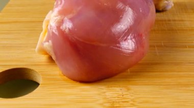 Kesme tahtasındaki taze tavuk bacakları..