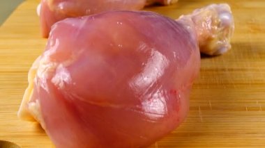 Kesme tahtasındaki taze tavuk bacakları..