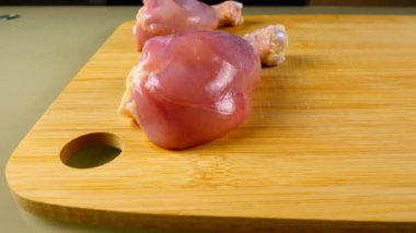 Kesme tahtasındaki taze tavuk bacakları..