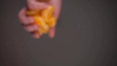 Soyulmuş mandalina dilimleri cam bir yüzeyde suya düşer. Alt manzara. Yavaş çekim.