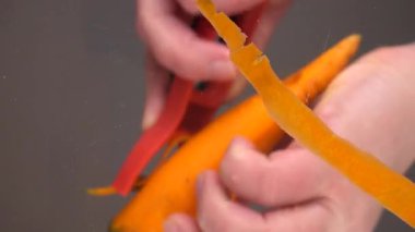 Cam bir kasenin üzerine taze havuç soymak. Alt görünüm.