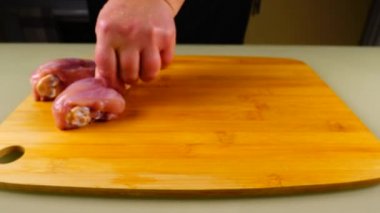 Taze tavuk bacakları kesme tahtasının üzerine serilmiştir..