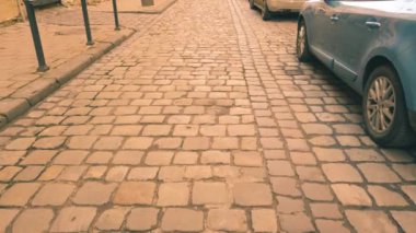 Eski kaldırım taşı sokakları ve park edilmiş arabalar..