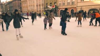 LVIV, UKRAINE - 5 Ocak 2021: Bilinmeyen insanlar şehir meydanında kayıyorlar.