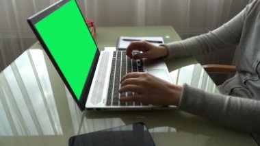 Ev işlerinde çalışan klavyede çalışan kız. Ekran yeşil bir arkaplan.