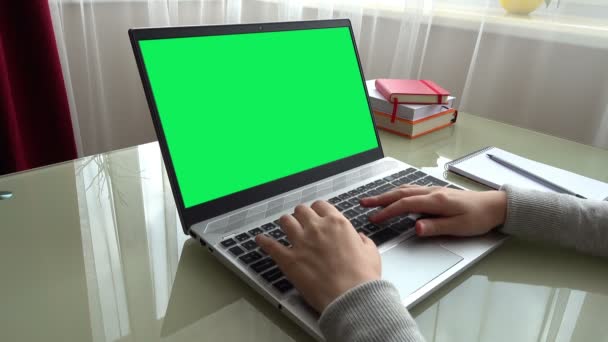 自宅のオフィスでキーボードを手に働く少女 画面は緑の背景です — ストック動画
