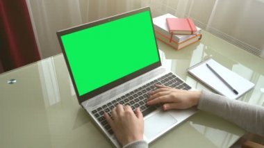 Ev işlerinde çalışan klavyede çalışan kız. Ekran yeşil bir arkaplan.