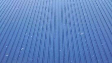 Mavi bir duvara karşı kar fırtınası.