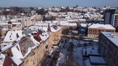 Binanın üzerinde uçan bir İHA 'nın hava görüntüsü. Kışın çekimler, karla kaplı çatılar..