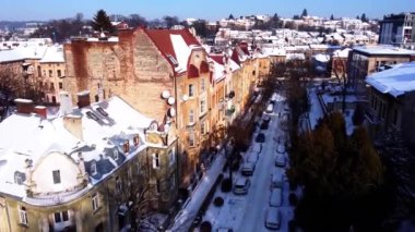 Binanın üzerinde uçan bir İHA 'nın hava görüntüsü. Kışın çekimler, karla kaplı çatılar..