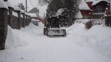 LVIV, UKRAINE - 13 Şubat 2021: Traktör kar fırtınasından sonra kar yolunu temizler.
