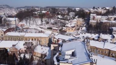 Binanın üzerinde uçan bir İHA 'nın hava görüntüsü. Kışın çekimler, karla kaplı çatılar..