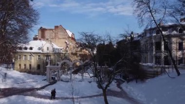 Binanın üzerinde uçan bir İHA 'nın hava görüntüsü. Kışın çekimler, karla kaplı çatılar..