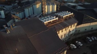 Bira üretim fabrikasının üzerinde uçan bir dronun hava görüntüsü, birkaç sıra tank....