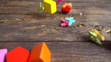 Çocukların tahta figürleri eski bir tahtaya düşer. Yavaş çekim.