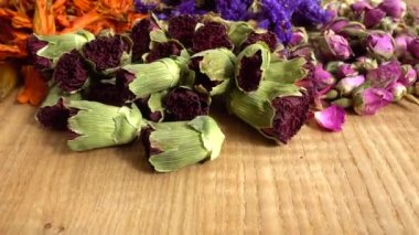 Flower teas on a wooden board. Jasmine flowers, Dianthus, Myosotis, lily petals, tea and French rose.