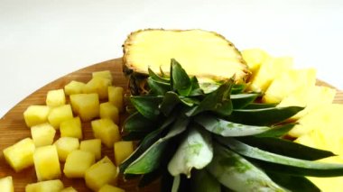 Pieces of pineapple on a cutting wooden board.